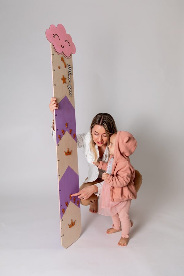 1. Woman and child interacting with lilac growth chart featuring cloud and raindrop design in studio setting