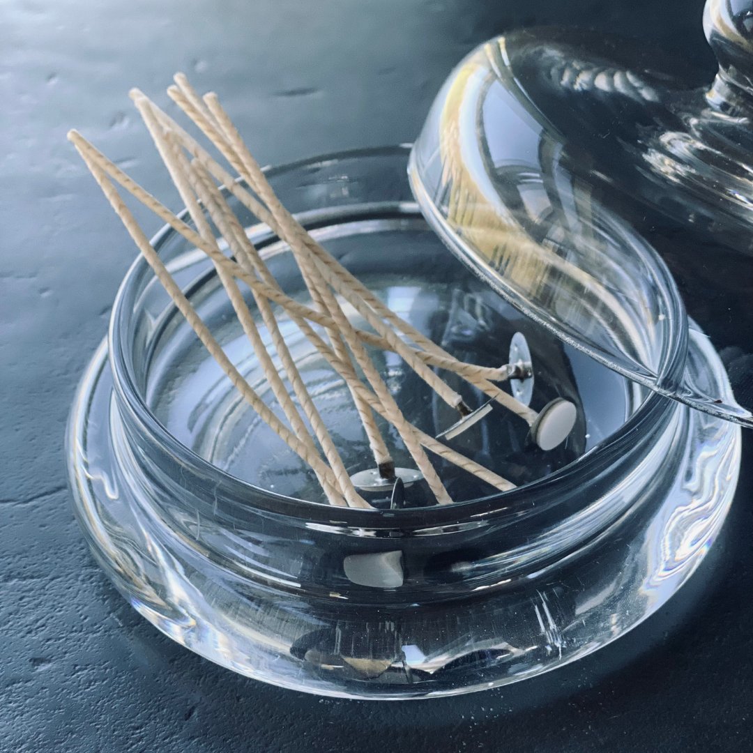 3. Close-up of extra wicks for powder candle in a clear glass dish with lid