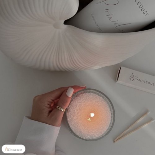 1. Woman lighting a Candledust powder candle with extra wicks, showcasing eco-friendly candle experience