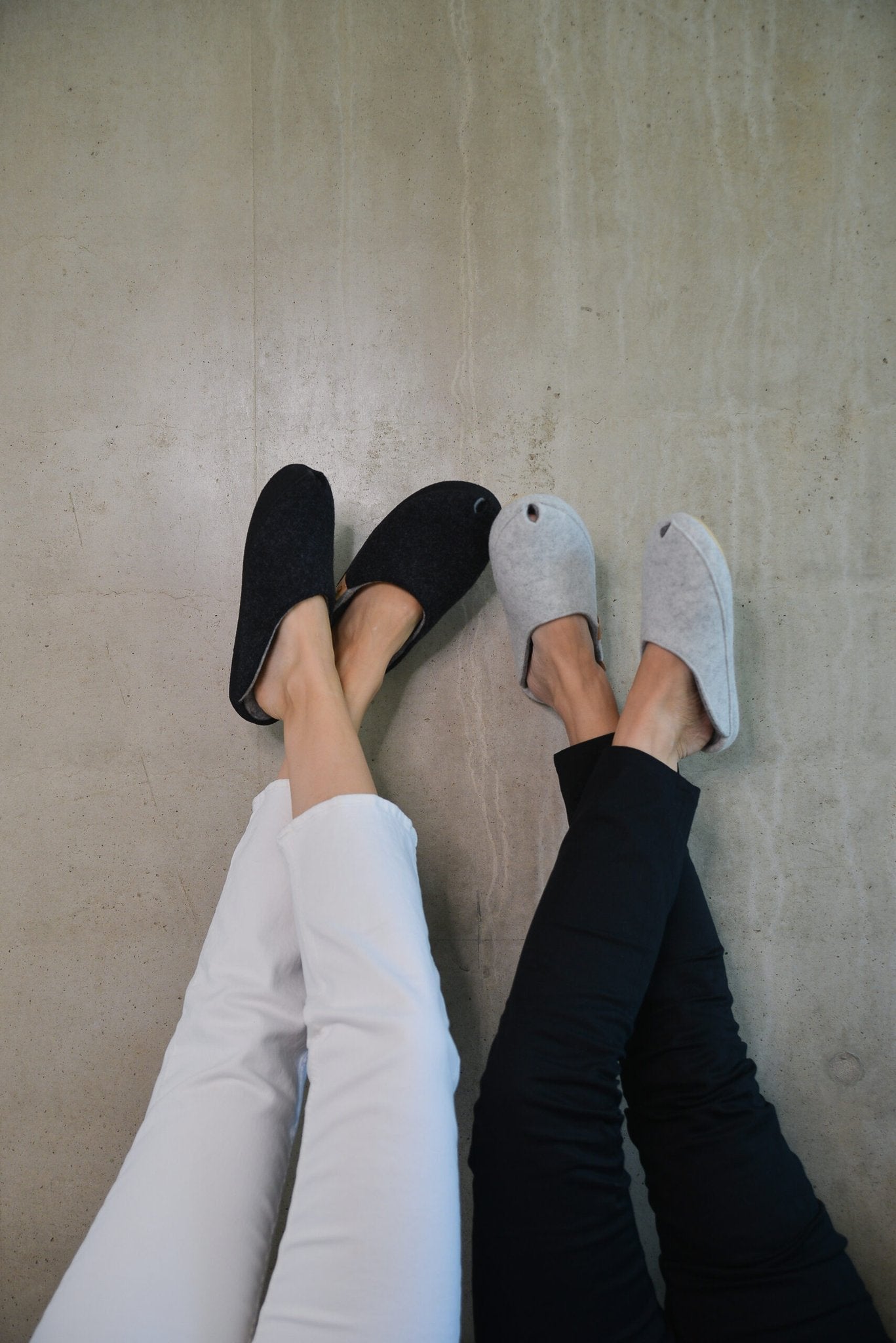 1. Lifestyle image of two women wearing TOKU Brussels Slippers in white and black, showcasing comfort and style