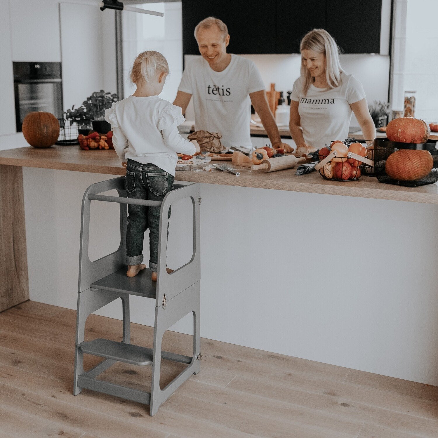 5. Family with child using grey kitchen tower for cooking on kitchen island