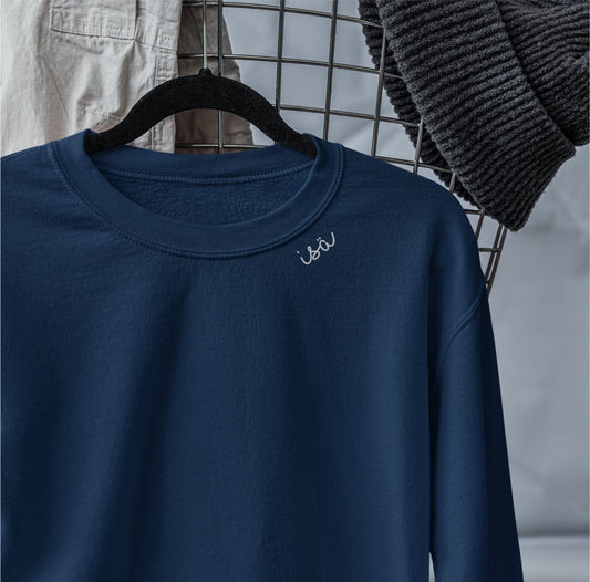 2. Navy organic cotton sweatshirt with 'Isä' embroidery on hanger, styled with casual clothing