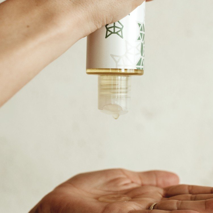 4. Hand pouring Vegan Fox Aloe Vera Body Oil from bottle