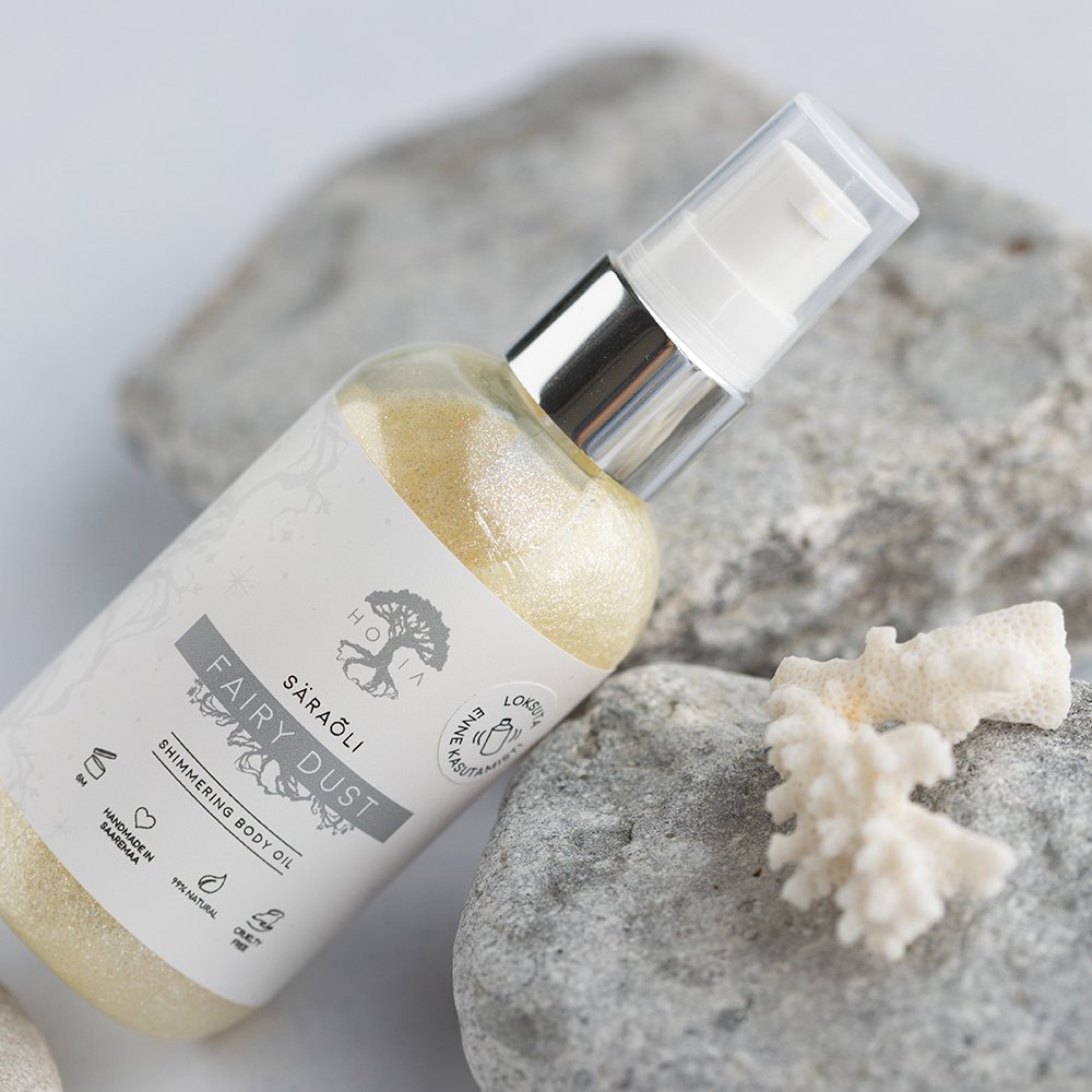 2. HOIA homespa Shimmering Body Oil Fairy Dust, 100ml bottle with eco-friendly shimmer, displayed with coral and stones