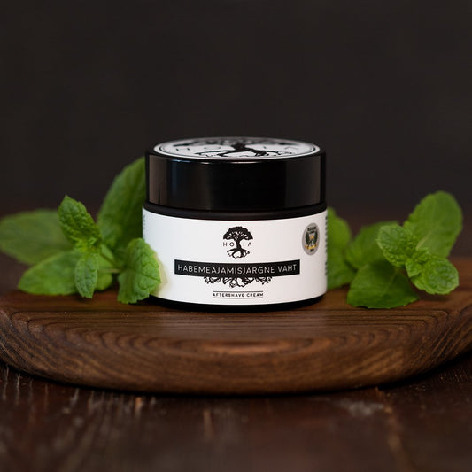 1. HOIA homespa men's aftershave foam in 50ML jar with peppermint leaves, showcasing natural and organic ingredients, antibacterial and anti-aging properties, on a wooden surface
