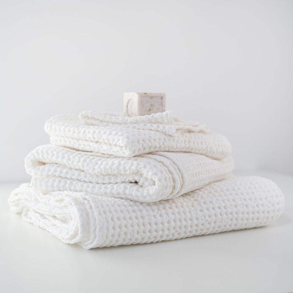 1. Stack of white honeycomb waffle towels with a soap bar on top, showcasing texture and volume