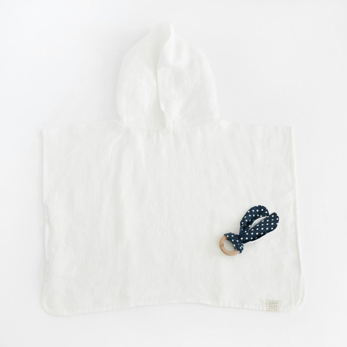 4. Flat lay of white linen waffle poncho with hood and polka dot accessory