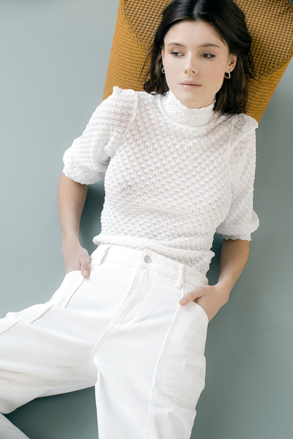 2. Woman wearing MyaMoon square hoop earrings in silver, paired with a white textured top and pants, highlighting Nordic minimalism