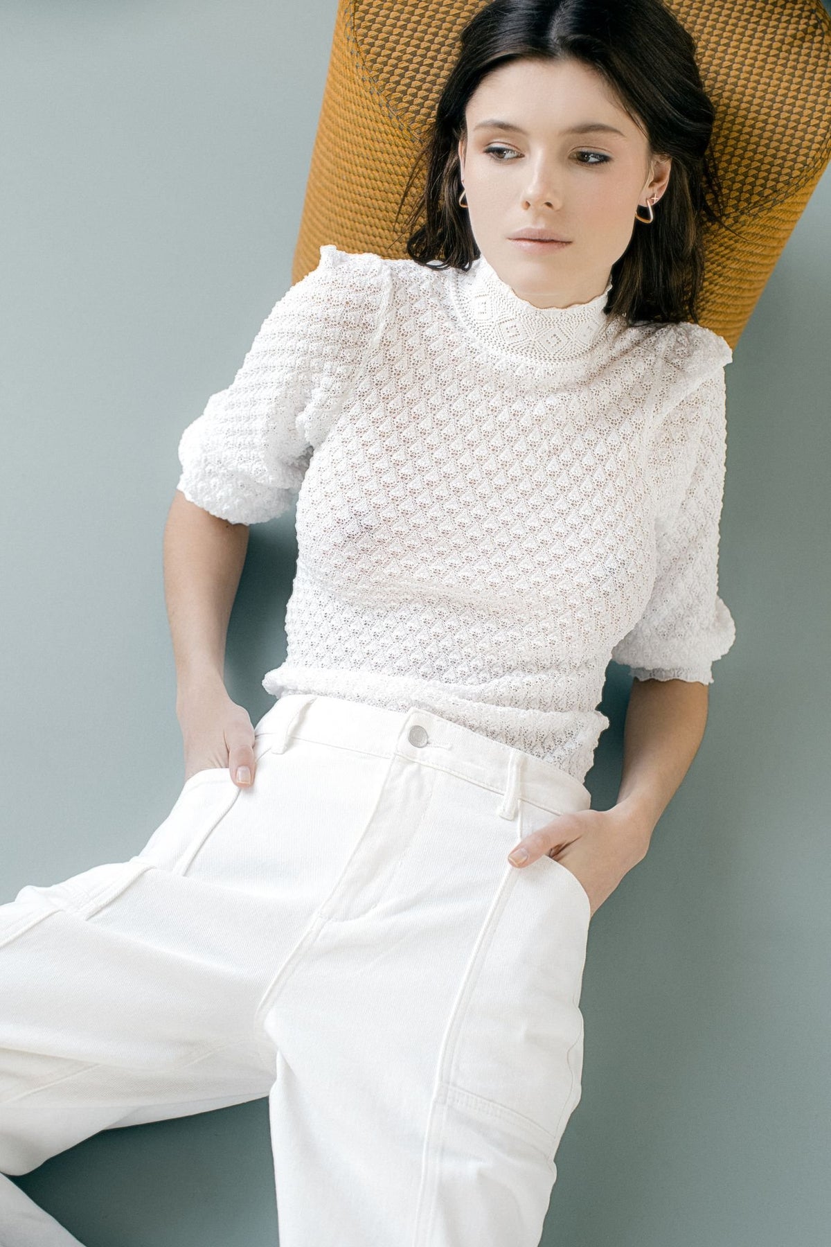 2. Woman wearing MyaMoon square hoop earrings in silver, paired with a white textured top and pants, highlighting Nordic minimalism
