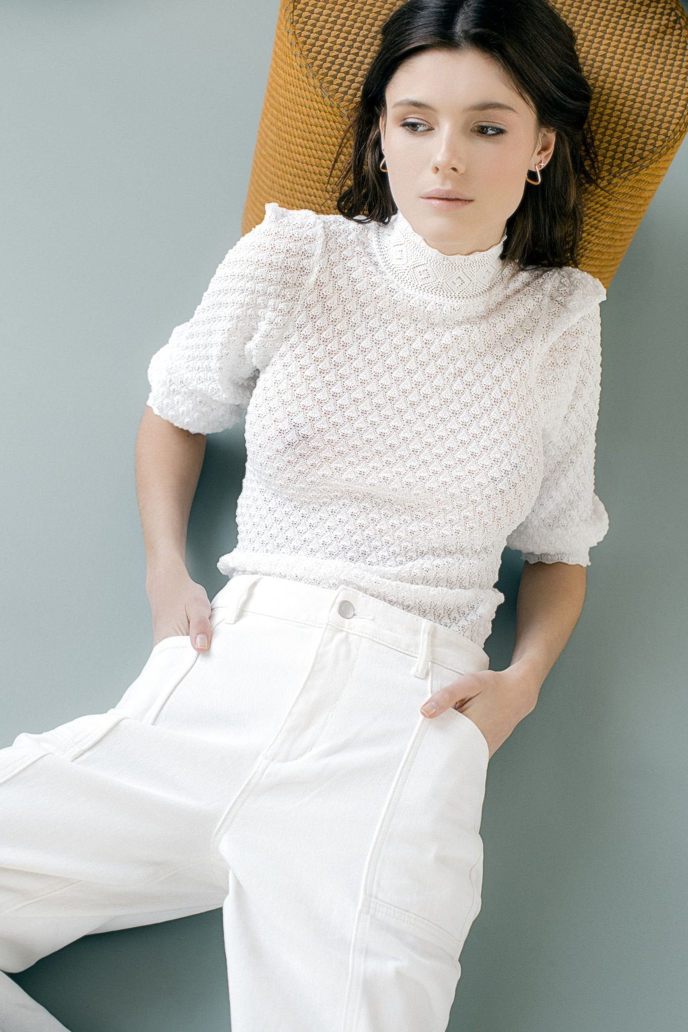 2. Woman wearing MyaMoon square hoop earrings in silver, paired with a white textured top and pants, highlighting Nordic minimalism