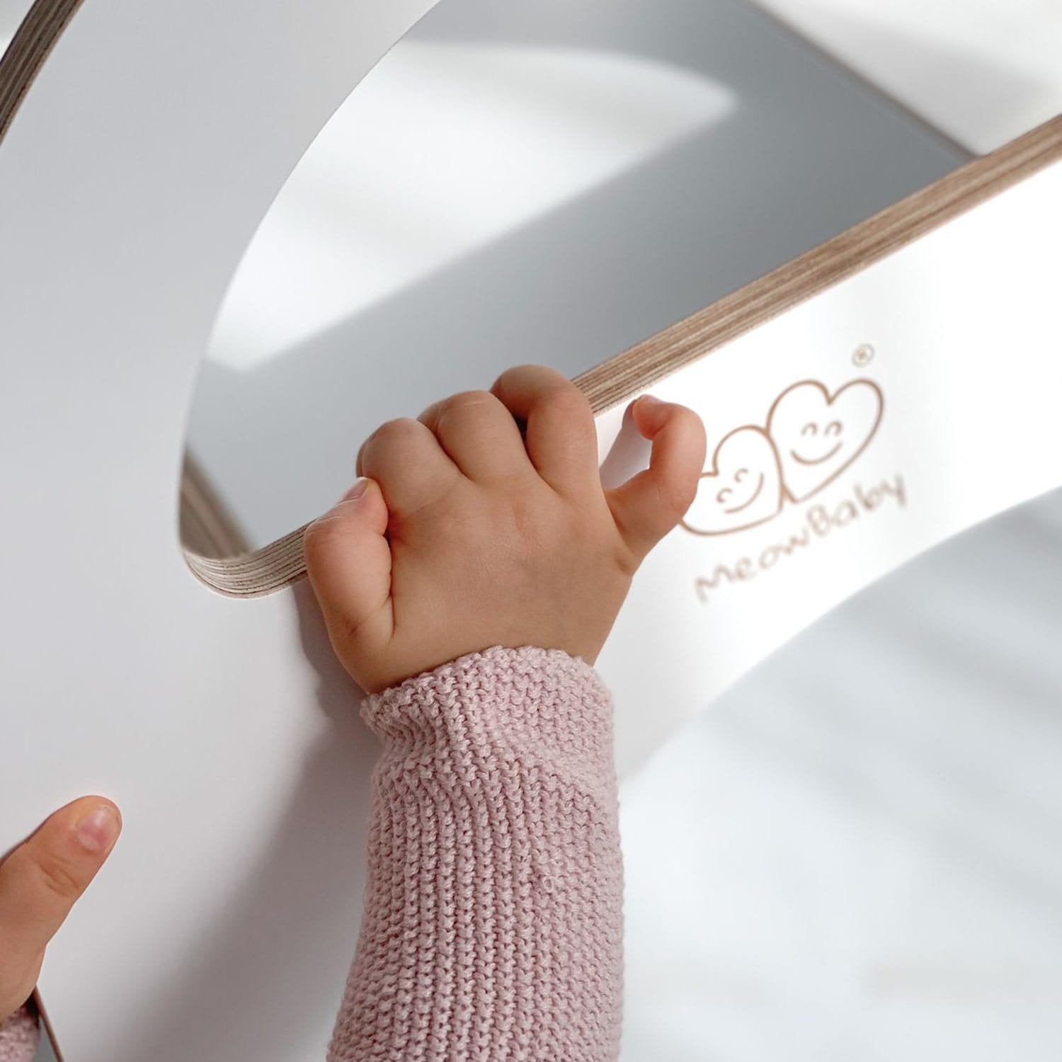 3. Close-up of child's hand holding the handle of a white wooden slide