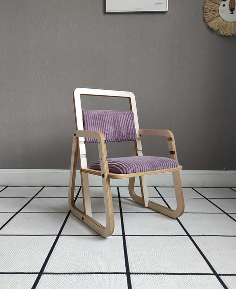 1. Children's adjustable chair in cannon pink with wooden frame and armrests in a modern room setting