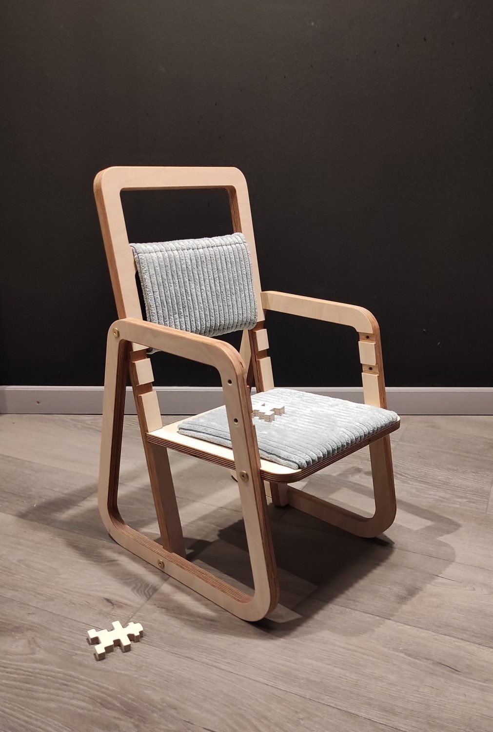 7. Mint green children's chair with puzzle piece on wooden floor