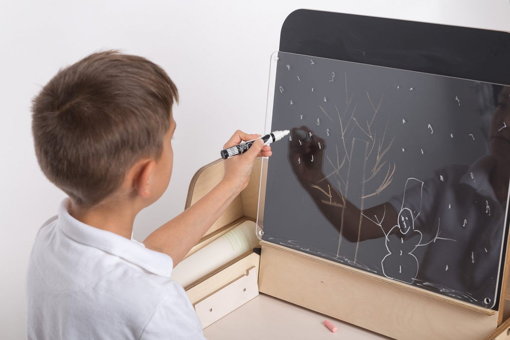 3. Close-up of boy using chalkboard on Montessori table