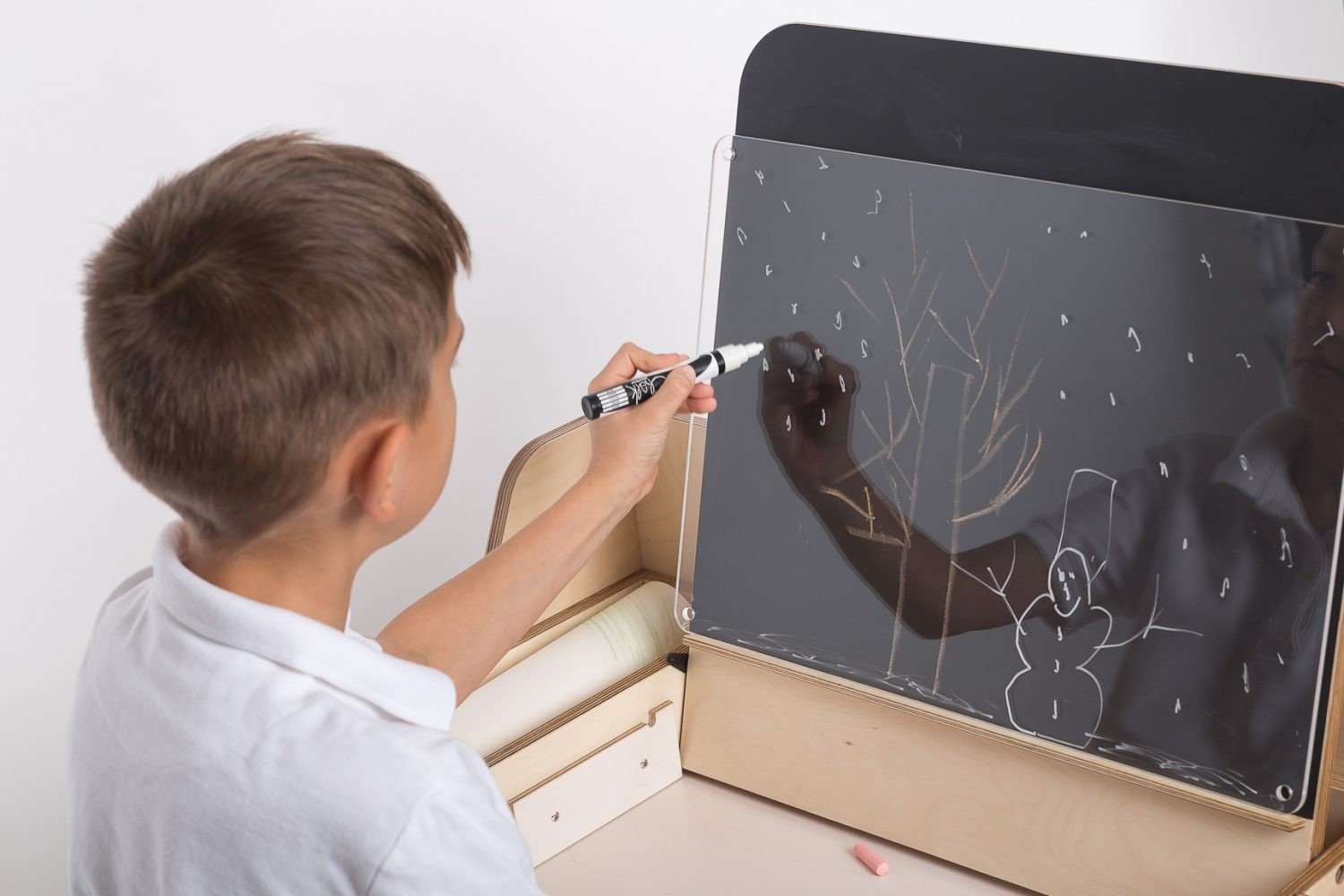 3. Close-up of boy using chalkboard on Montessori table