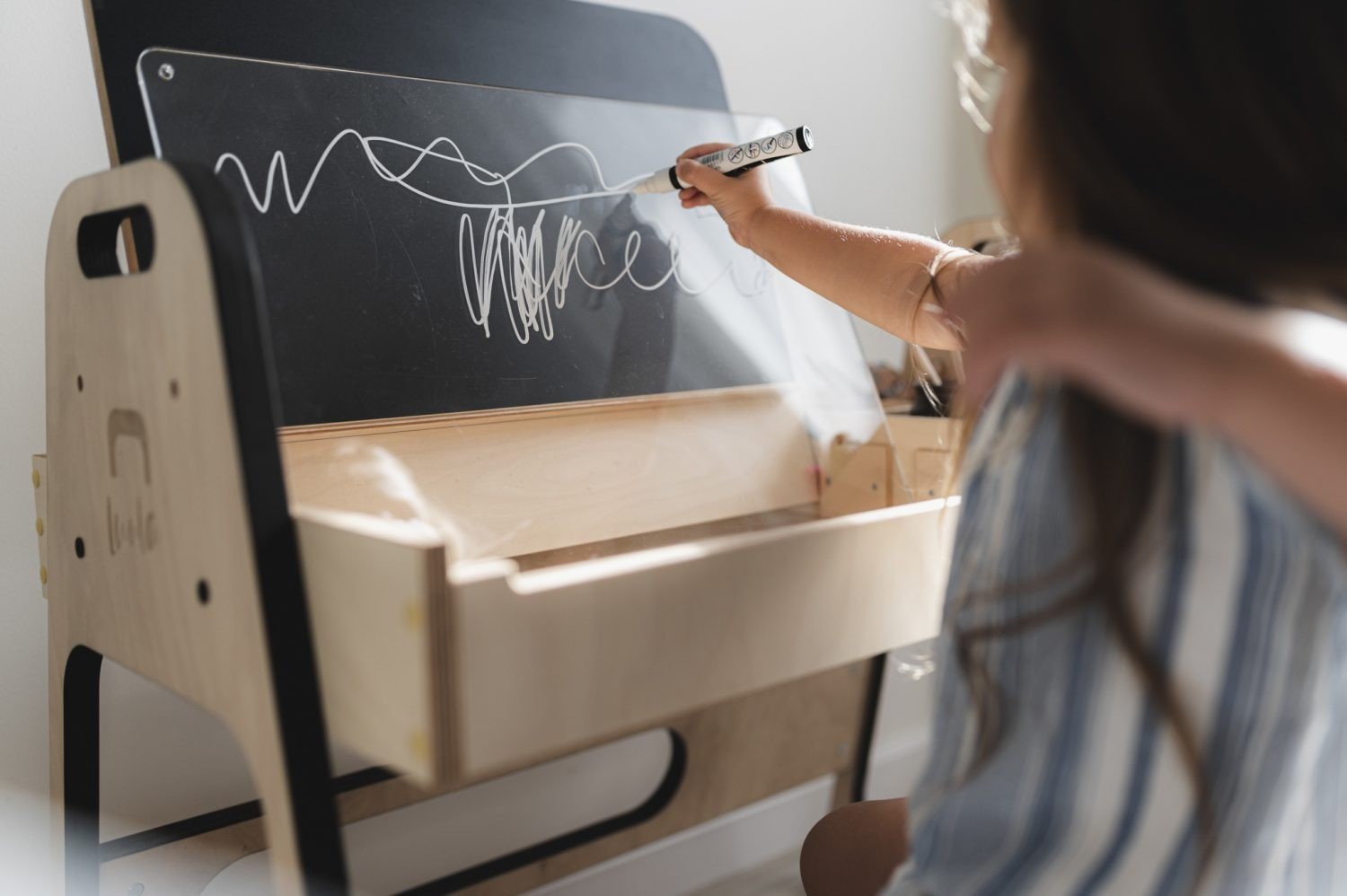 18. Boy using chalkboard on Luula Julle table, showcasing educational features