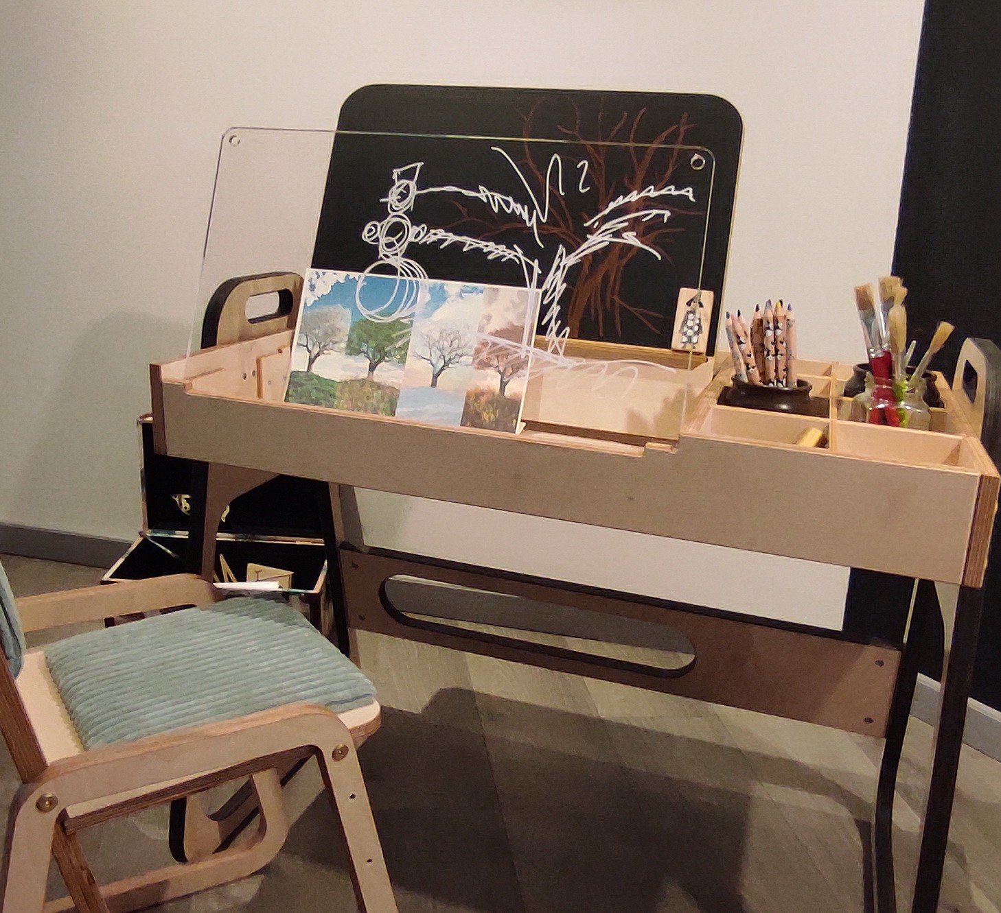 12. Close-up of Luula Julle table with open storage and chalkboard, showcasing versatility