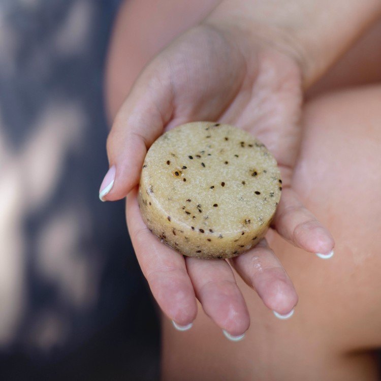 5. Hand holding Vegan Fox body scrub bar with kiwi seeds, emphasizing exfoliating texture and natural ingredients