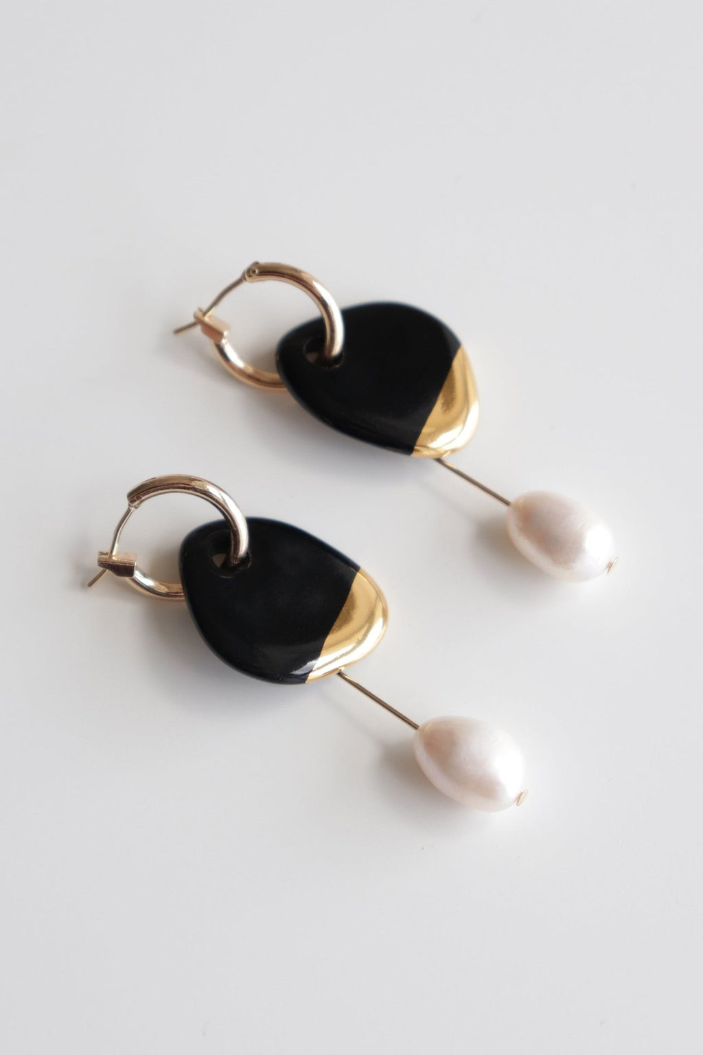3. Studio shot of Rozenthal Arp Pearl And Porcelain Earrings in black with gold-plated hoops and pearls