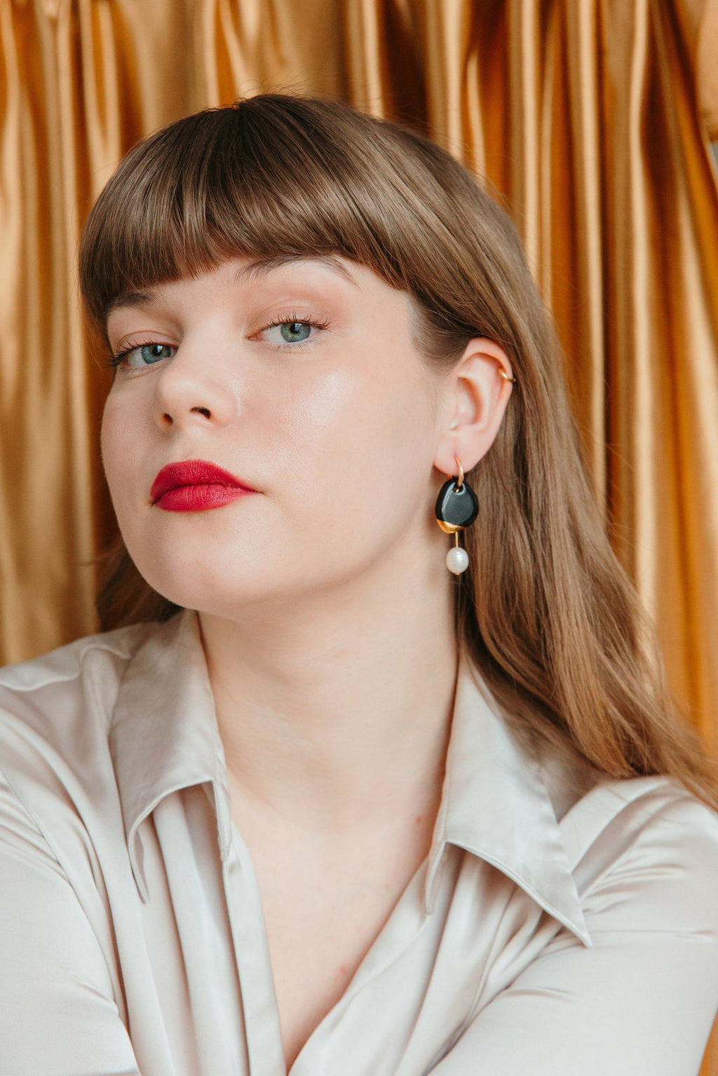 2. Woman wearing Rozenthal Arp Pearl and Porcelain Earrings in black, highlighting luxury style