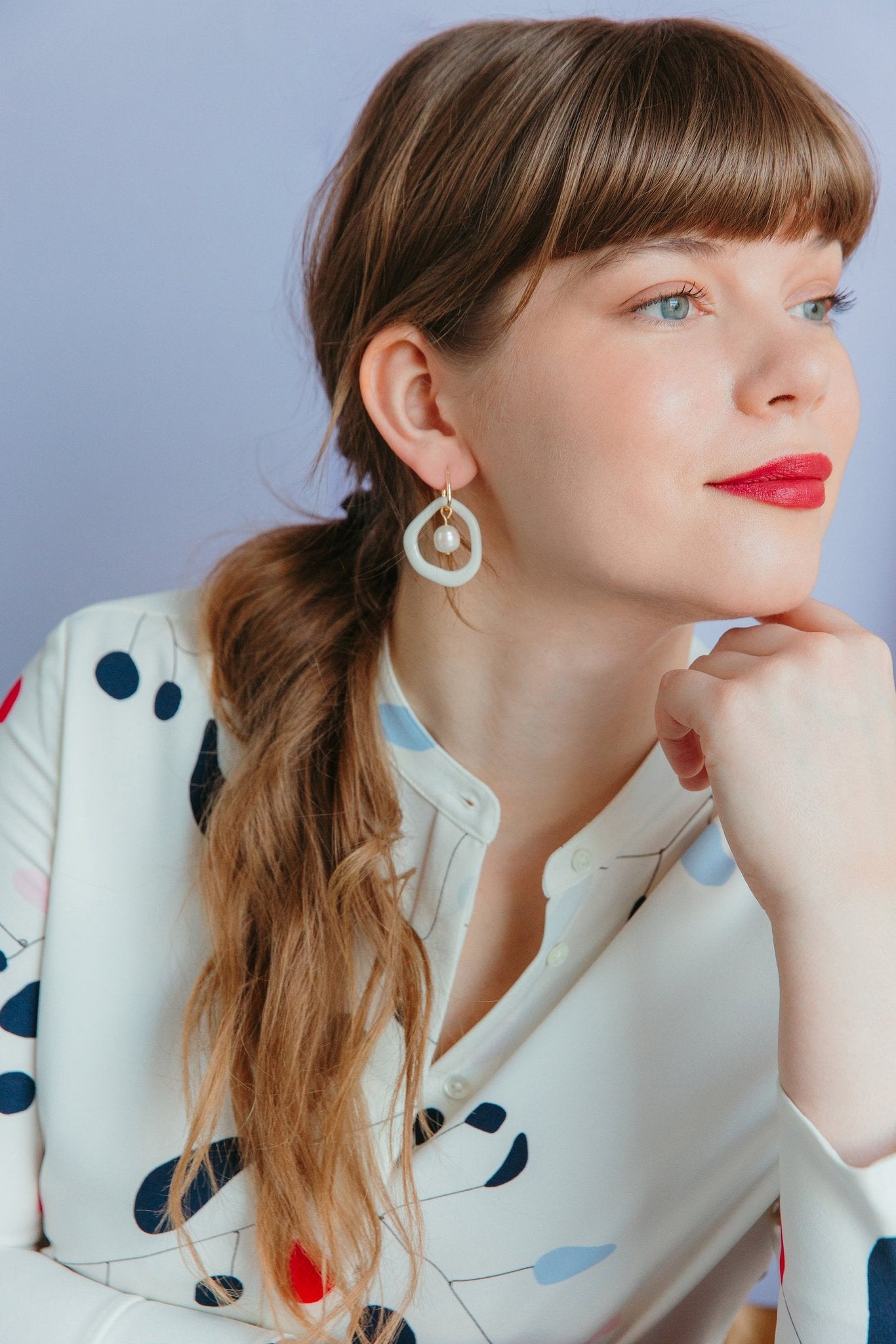 15. Woman wearing Rozenthal Arp Pearl and Porcelain Hoops in white, showcasing elegant biomorphic design