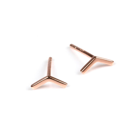 2. Pair of small rose gold arrow earrings on a white background