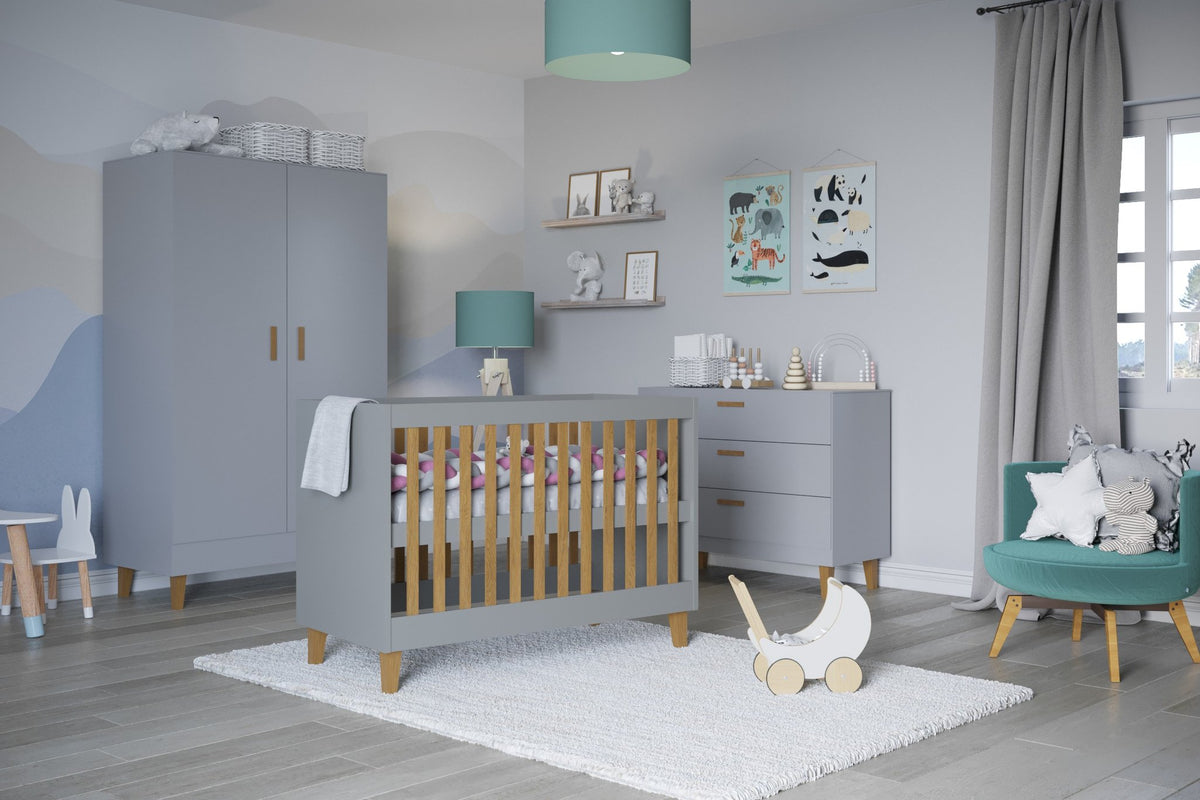 1. Grey baby cot with oak slats in modern nursery setting, surrounded by matching furniture and decor