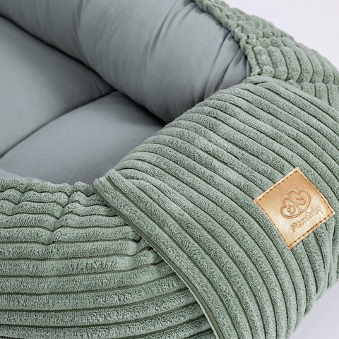 3. Close-up of MeowBaby logo on ribbed olive green fabric of baby nest