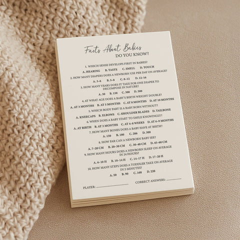 1. Stack of Beebila Baby Facts trivia game cards on textured fabric, featuring fun questions about babies, printed on thick cream Munken Pure paper, size A6