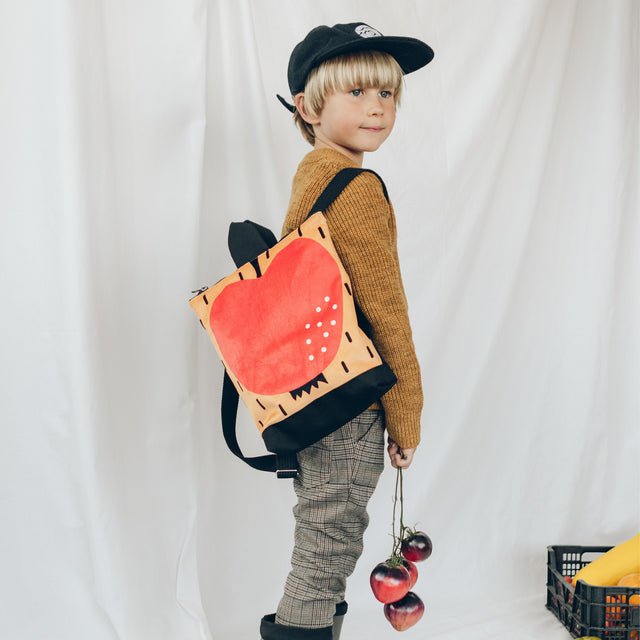 3. Child wearing Muni apple backpack, perfect for young adventurers, shown in lifestyle setting