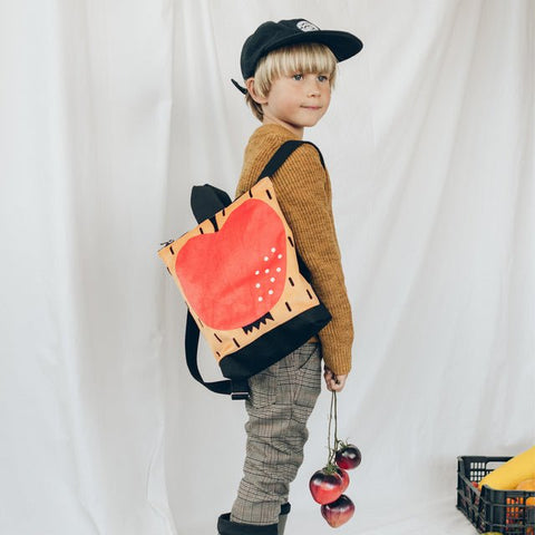 3. Child wearing Muni apple backpack, perfect for young adventurers, shown in lifestyle setting