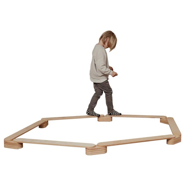 1. Child balancing on wooden leg&go balance beams set of 6 in a hexagonal shape on a white background