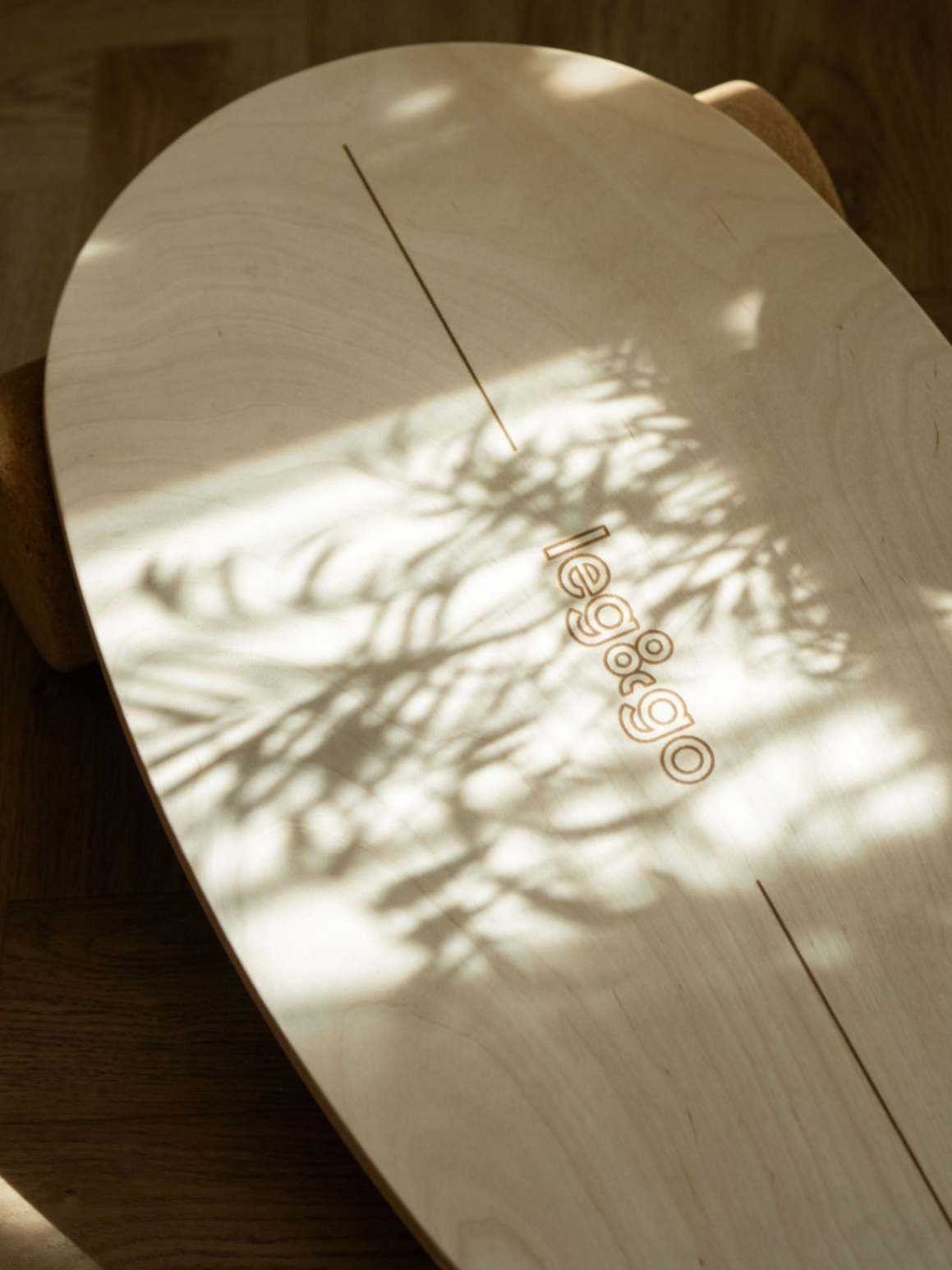 3. Close-up of leg&go logo on wooden balance board with shadow pattern
