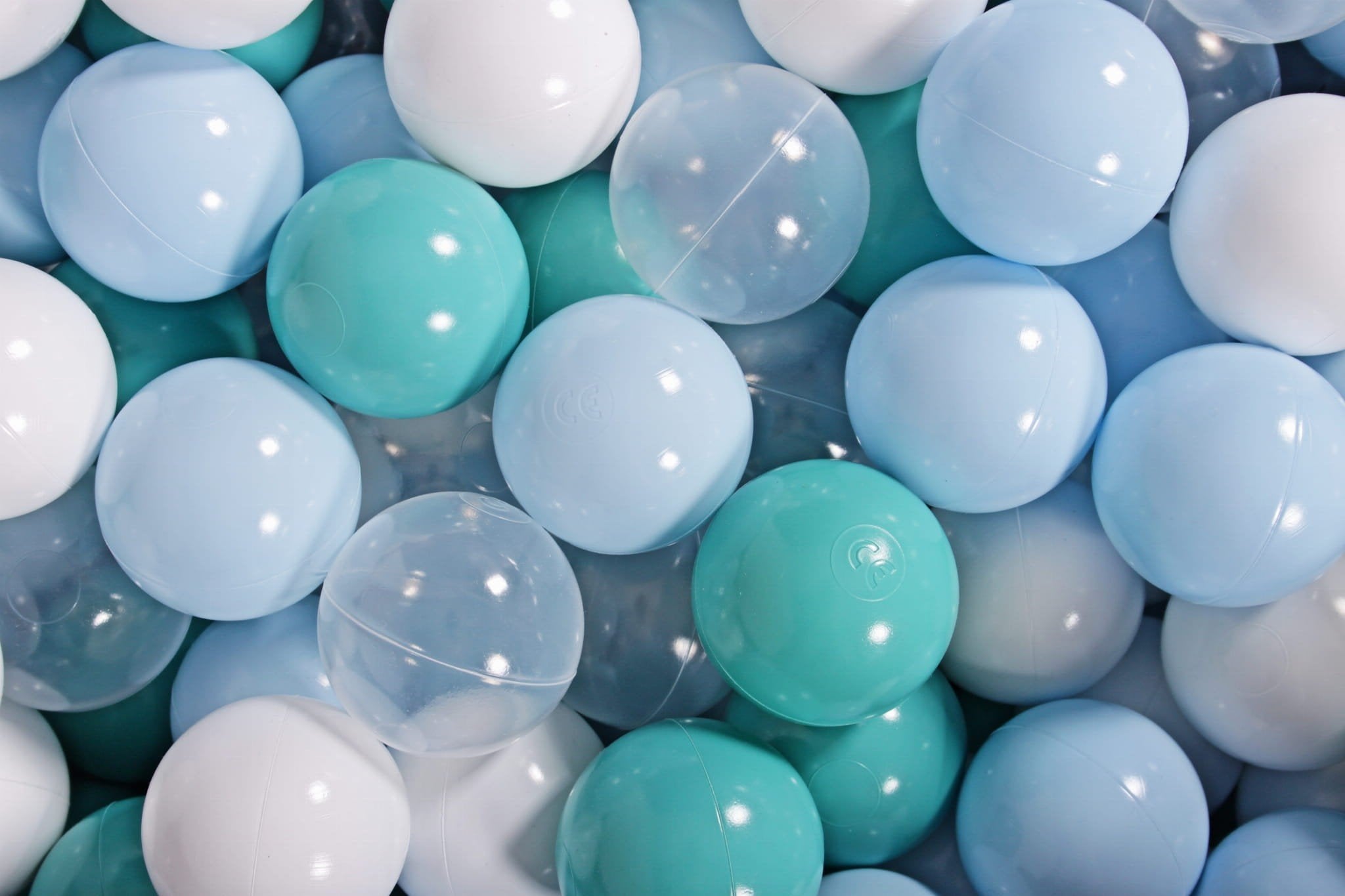 1. Close-up of MeowBaby ball pit balls in blue, turquoise, transparent, and white colors, showcasing shiny and flexible plastic surface, ideal for children's play and sensory integration therapy.