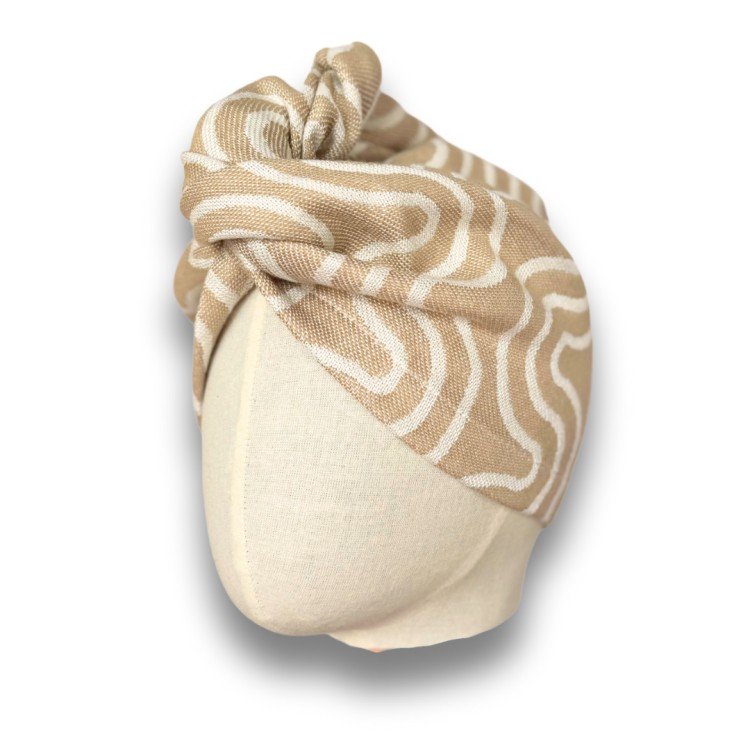 3. Beige and white patterned bamboo-cotton hair turban from Patulove shown on mannequin head with studio lighting