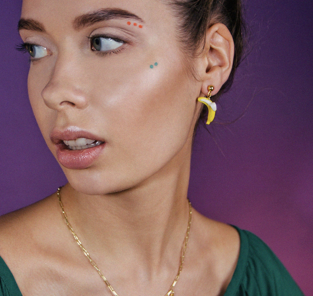 1. Woman wearing SCULP Banana Love earrings with playful design, shown in lifestyle setting