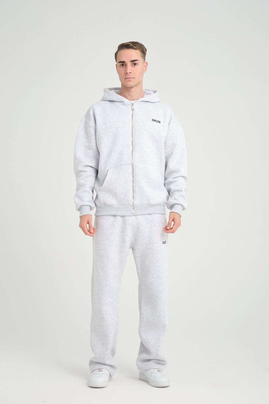 1. Man wearing grey melange jogger pants and matching hoodie, standing in studio setting