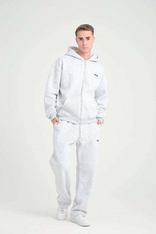 1. Man in grey melange jogger pants and hoodie, walking in studio setting