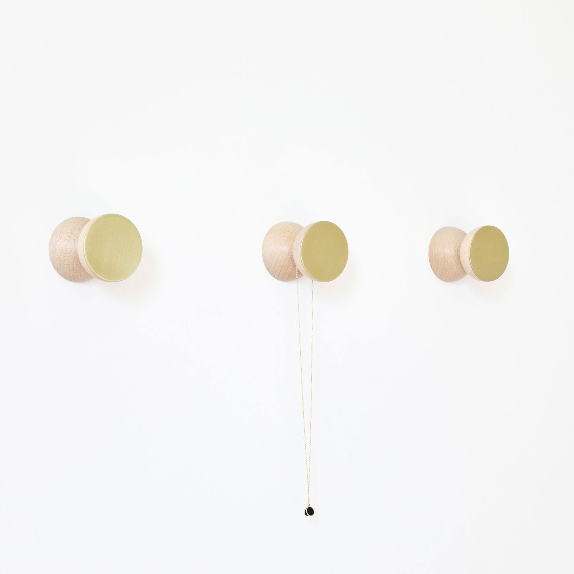 2. Pair of beech wood and brass wall hooks by 5mm Paper, studio side view