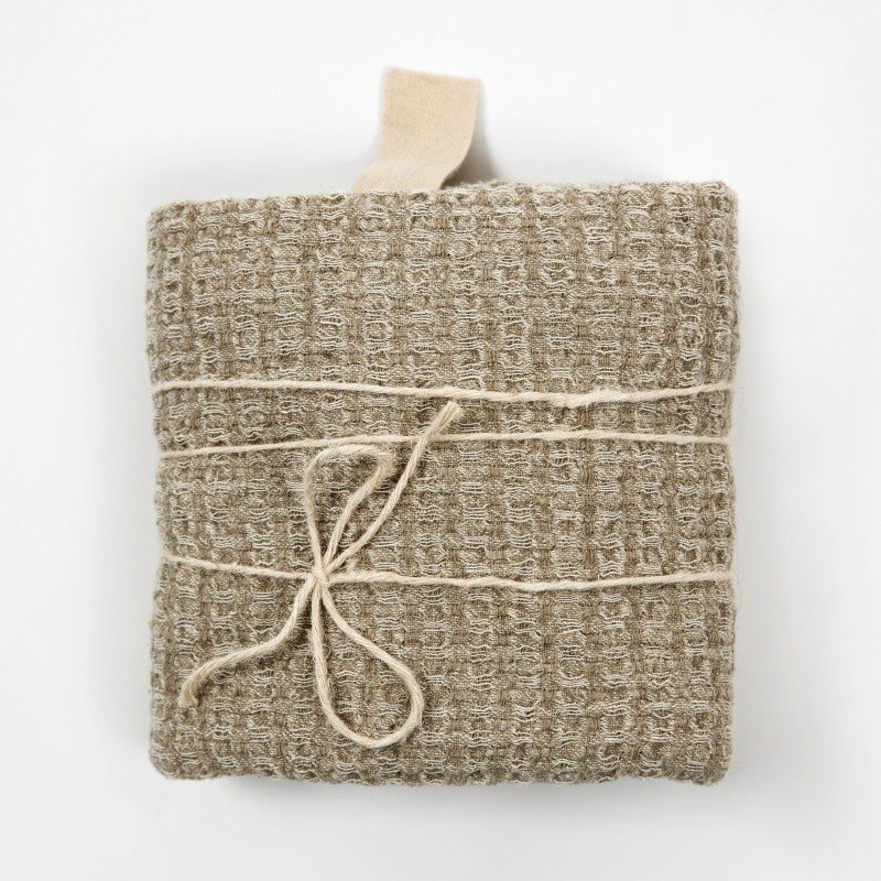 1. Folded grey textured linen towel with cotton hanger and tied with string on white background
