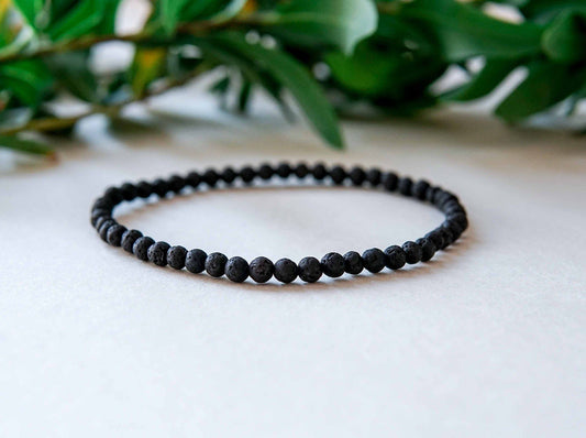 2. Studio shot of men's Black Lava Anklet by Canary Lava with polished lava stones and Baltic amber bead
