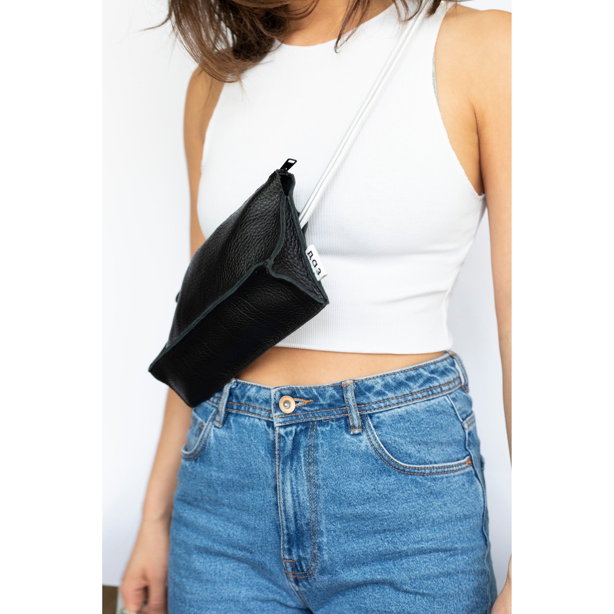 1. Women's handmade leather bum bag in black and white by Daz Studio, worn crossbody with casual outfit