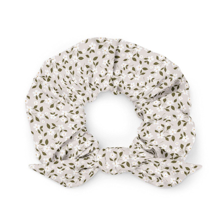 1. Beige scrunchie with floral pattern and bow detail made from recycled polyester, shown in a flat lay on a white background