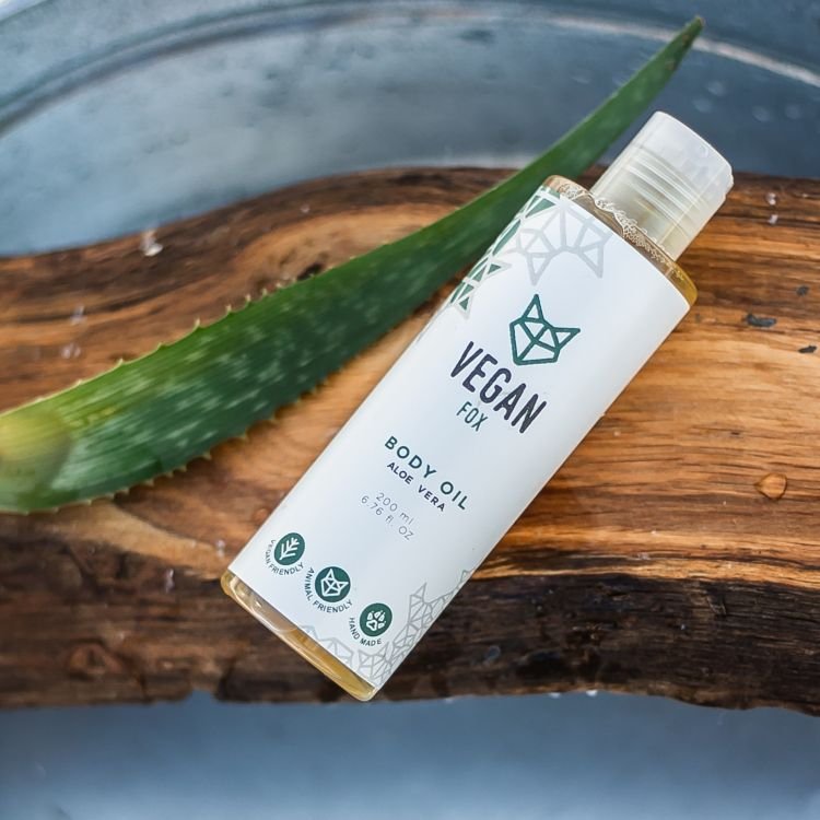 3. Vegan Fox Aloe Vera Body Oil bottle on wooden surface with aloe leaf