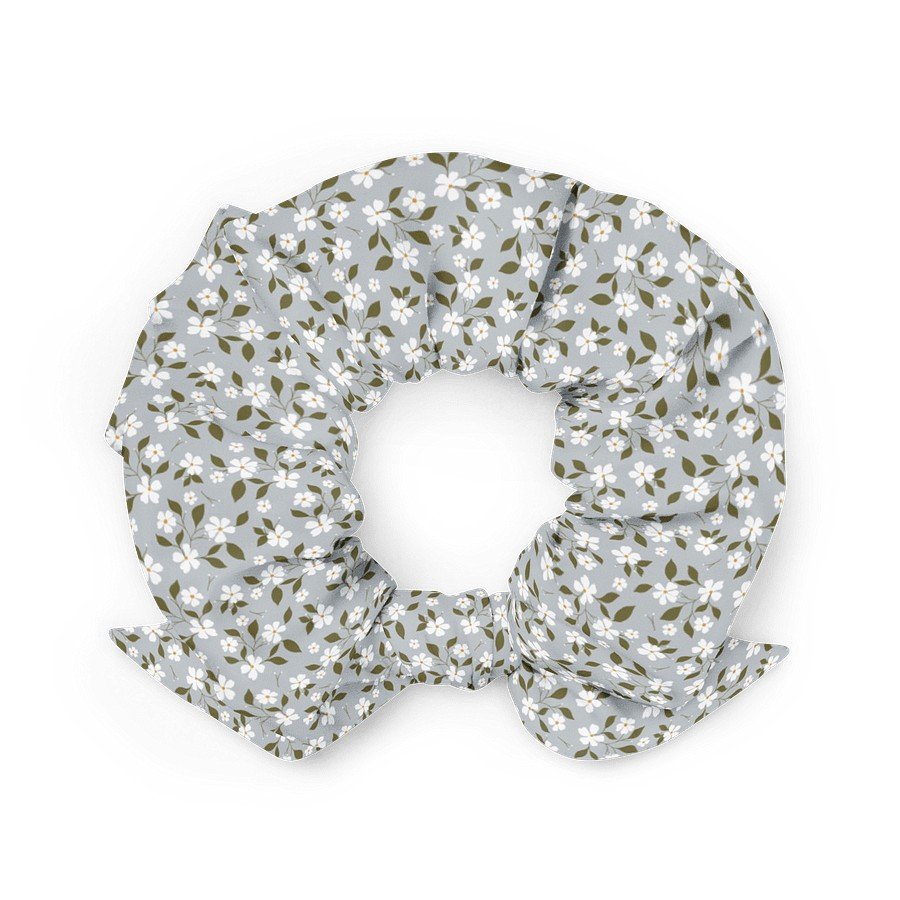 2. Blue floral scrunchie with bow, featuring white flowers and green leaves, displayed flat on a white background