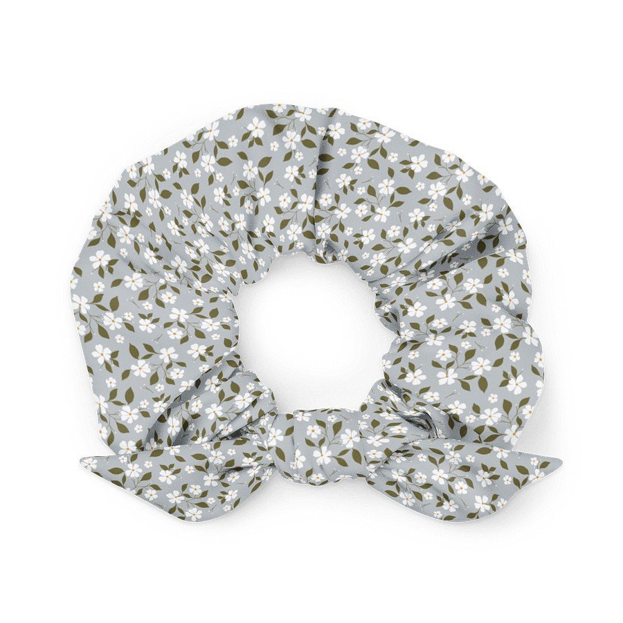 1. Blue scrunchie with white floral pattern and bow detail, made from recycled polyester, shown in a flat lay on a white background