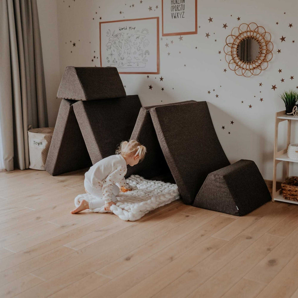 2. Child playing with Monboxy dark brown play mattress set in a cozy room with wooden floor