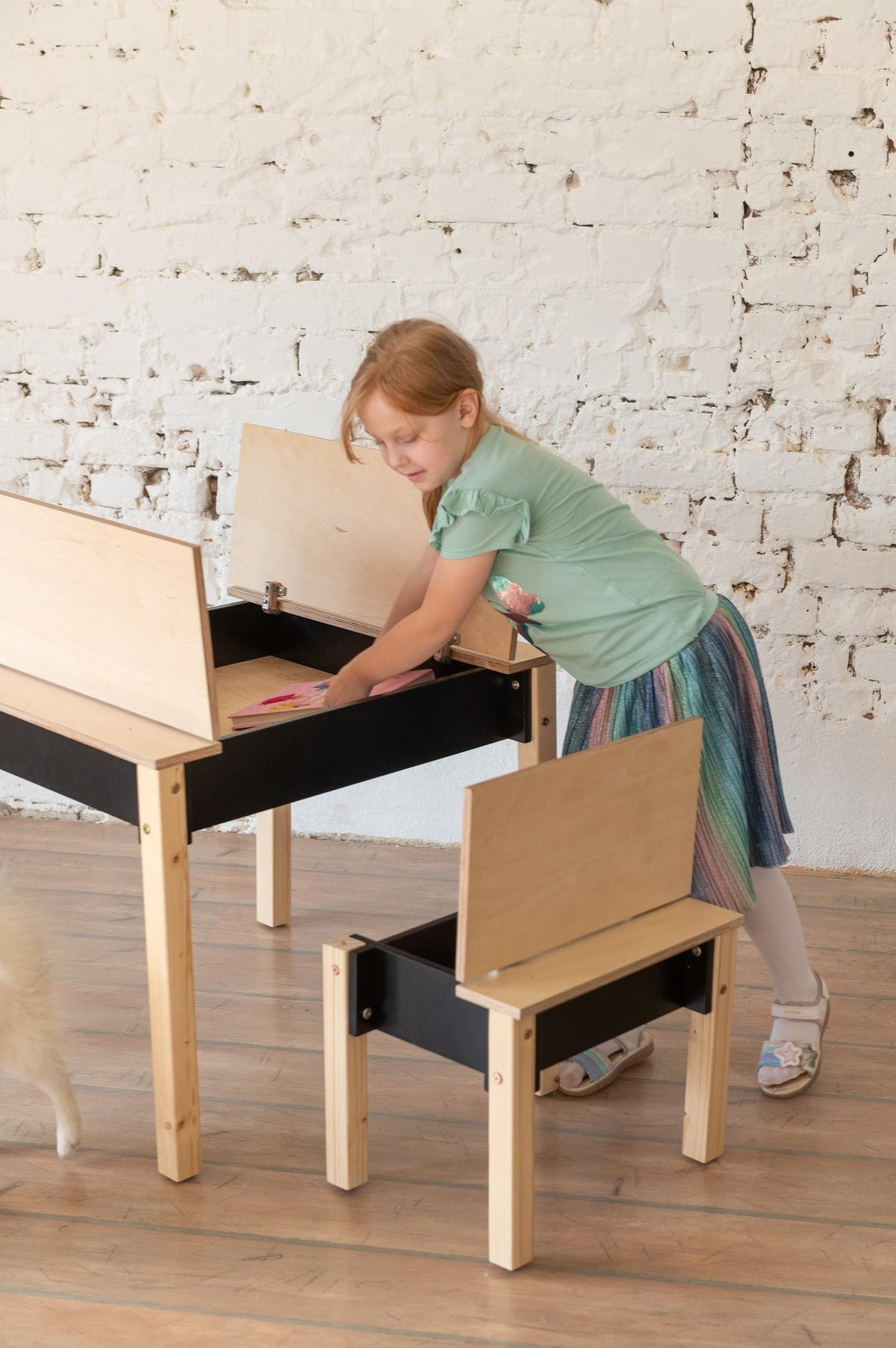 2. Studio shot of children's smart storage table and chair set in light wood and black, closed storage compartments