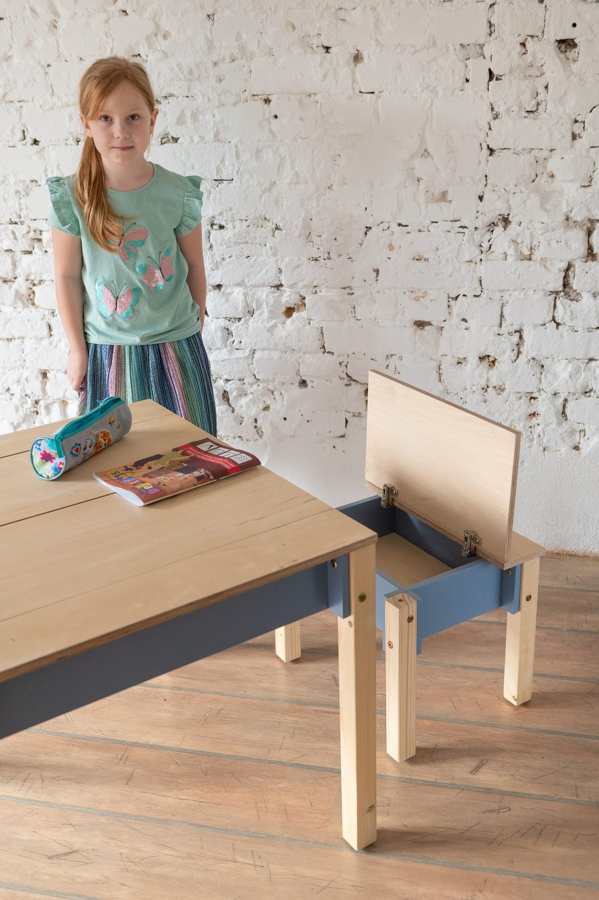 2. Studio shot of children's smart storage table and chair set in light wood and grey, closed storage compartments