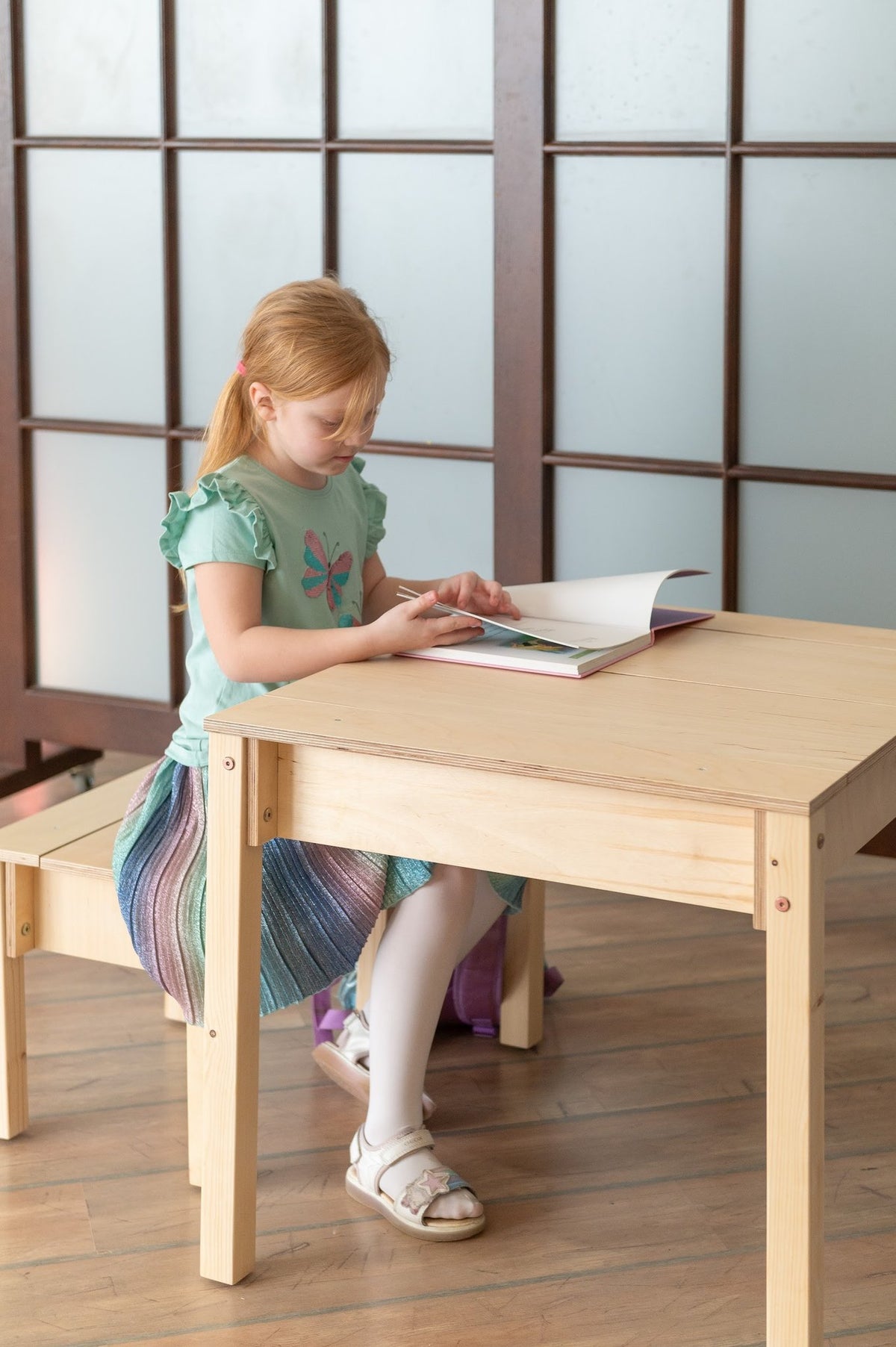1. Girl reading at smart storage table and chair set in a playroom